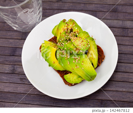 Tasty avocado toasts on white plate Tasty avocado toasts on white plate 142467812