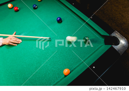 Young man trying to hit the ball in billiard. 142467910