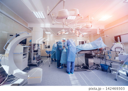 Process of trauma surgery operation. Group of surgeons in operating room with surgery equipment. Process of trauma surgery operation. Group of surgeons in operating room with surgery equipment. 142469303