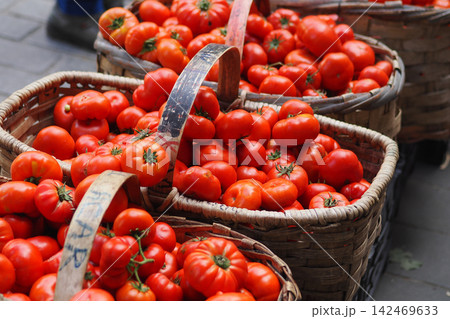 Red tomatoes in baskets at a market stall Red tomatoes in baskets at a market stall 142469633