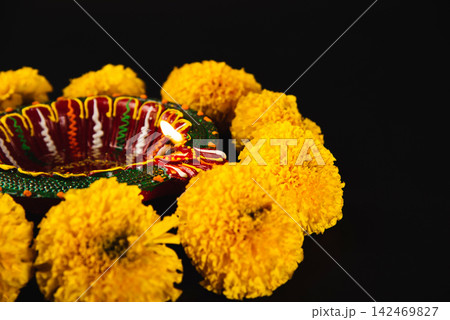 Celebrate Diwali with elegance, A Diwali lamp and floral rangoli on a captivating black backdrop. Ideal for Diwali, weddings, and religious festivities. Celebrate Diwali with elegance, A Diwali lamp and floral rangoli on a captivating black backdrop. Ideal for Diwali, weddings, and religious festivities. 142469827
