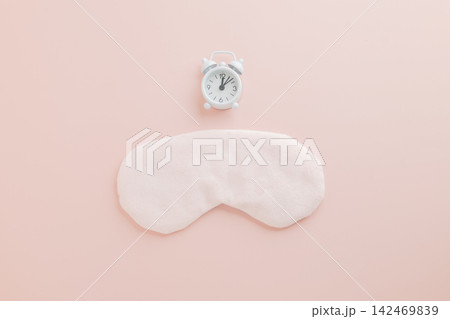 Stylish flat lay for World Sleep Day, eye mask and clock on pink background. 142469839
