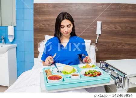 Tray with breakfast for the young female patient. The young woman eating in the hospital. Tray with breakfast for the young female patient. The young woman eating in the hospital. 142469954