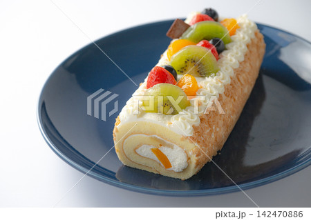 紺色の皿の中央に置かれたロールケーキ 紺色の皿の中央に置かれたロールケーキ 142470886