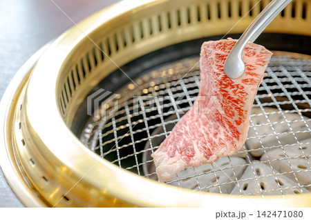 網の上に牛肉を乗せる焼肉の一場面 142471080