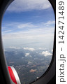 Aerial view of a tropical coastline through an aircraft window 142471489