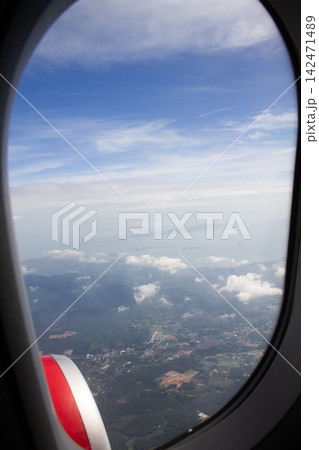 Aerial view of a tropical coastline through an aircraft window 142471489