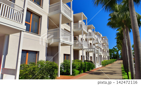 European residential architecture harmonizing with nature. Eco-friendly living in city with greens. Eco apartment building saving energy and fresh air concept. European residential architecture harmonizing with nature. Eco-friendly living in city with greens. Eco apartment building saving energy and fresh air concept. 142472116