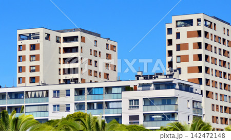 European residential architecture harmonizing with nature. Eco-friendly living in city with greens. Eco apartment building saving energy and fresh air concept. European residential architecture harmonizing with nature. Eco-friendly living in city with greens. Eco apartment building saving energy and fresh air concept. 142472148