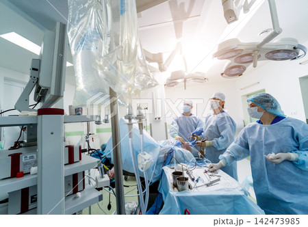 Arthroscope surgery. Orthopedic surgeons in teamwork in the operating room with modern arthroscopic tools. Knee surgery. 142473985