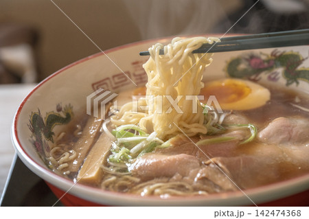 高く持ち上げた麺が主役のラーメン一杯 142474368
