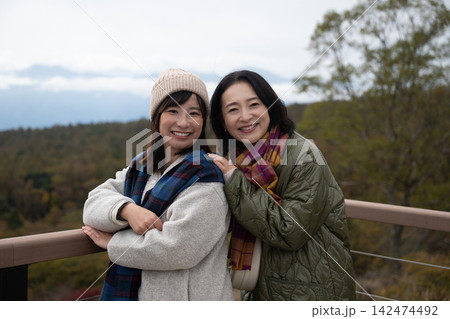 紅葉のススキ野原ではしゃぐ女性二人 紅葉のススキ野原ではしゃぐ女性二人 142474492