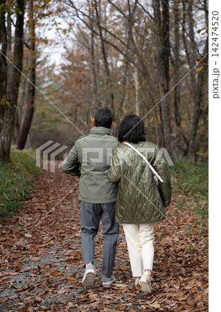 八ヶ岳山麓の紅葉の森を歩く中高年夫婦 八ヶ岳山麓の紅葉の森を歩く中高年夫婦 142474520