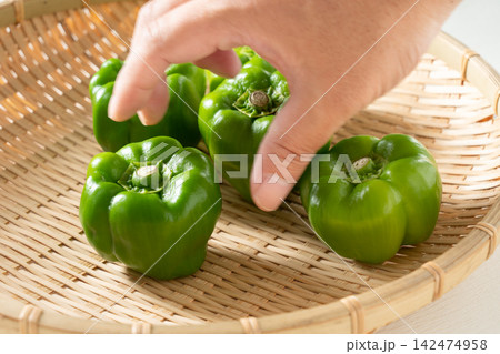 ザルにのせた伝統野菜のかぐら南蛮に手を伸ばす男性(9月) ザルにのせた伝統野菜のかぐら南蛮に手を伸ばす男性(9月) 142474958
