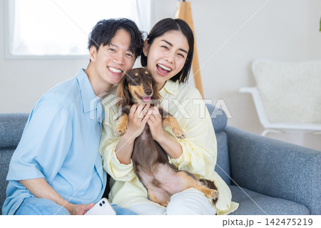 ファミリー　犬のいる暮らし　飼い主とミニチュアダックスのポートレート 142475219