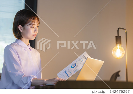 オフィスで資料のデータを読み込む女性ビジネスパーソン オフィスで資料のデータを読み込む女性ビジネスパーソン 142476297
