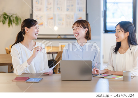 明るいオフィスで楽しそうに意見を交わす女性社員チーム 明るいオフィスで楽しそうに意見を交わす女性社員チーム 142476324
