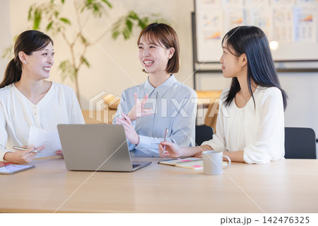 アイデア出しの会議で身振り手振りを交えて熱心に提案・プレゼンする女性社員 142476325
