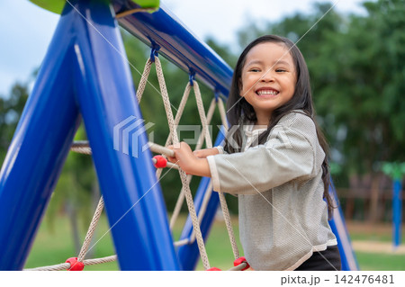happy preschool child girl climbing rope net at playground happy preschool child girl climbing rope net at playground 142476481