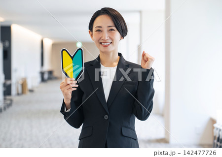 初心者マークを持つ女性。免許、ドライバー、運転、ビギナー、ガッツポーズ、やる気、元気、挑戦、スタート 初心者マークを持つ女性。免許、ドライバー、運転、ビギナー、ガッツポーズ、やる気、元気、挑戦、スタート 142477726