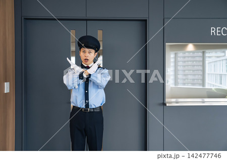 入口でストップをかける警備員。警備、セキュリティ、防犯、立入禁止、注意、違反、規則、企業、施設、受付 142477746