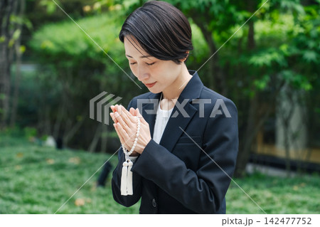 合掌する喪服の女性。墓地, お墓参り, 供養, 喪服, 葬式, 葬儀, 葬祭場, 樹木葬, 霊園 142477752