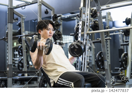 スポーツジムでトレーニングする若い男性 スポーツジムでトレーニングする若い男性 142477837