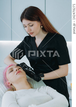 young woman getting an injection procedure in aesthetic clinic. Beauty treatment young woman getting an injection procedure in aesthetic clinic. Beauty treatment 142478271