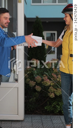 Vertical video. Man receives pizza delivery on bike. Vertical video. Man receives pizza delivery on bike. 142478429