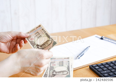 紙幣を持つ人の手元 お金の管理や支払いのイメージ素材 紙幣を持つ人の手元 お金の管理や支払いのイメージ素材 142480506