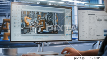 Engineer Supervising Live Robotic Arm Welding Stream on Monitor in Smart Factory Engineer Supervising Live Robotic Arm Welding Stream on Monitor in Smart Factory 142480595