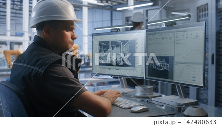 Engineer Analyzing Production Workflows on Dual Screens in Smart Factory Engineer Analyzing Production Workflows on Dual Screens in Smart Factory 142480633