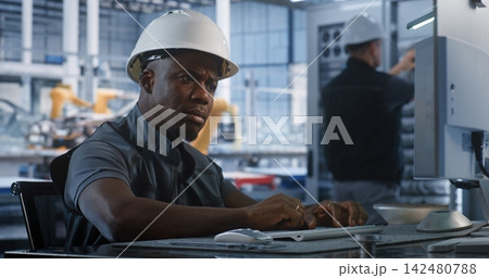 Specialist Operating Industrial Software in Factory Control Room Specialist Operating Industrial Software in Factory Control Room 142480788