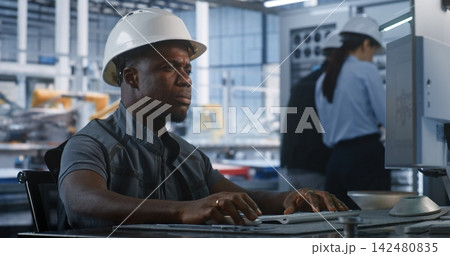 Engineer Monitoring Smart Factory Data at Workstation Engineer Monitoring Smart Factory Data at Workstation 142480835