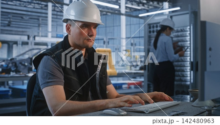 Engineer Working at Computer with Colleagues at Server Rack in Smart Factory Engineer Working at Computer with Colleagues at Server Rack in Smart Factory 142480963