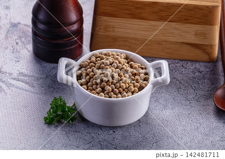 White peppercorns in ceramic bowl with wooden mill and fresh parsley on grey background White peppercorns in ceramic bowl with wooden mill and fresh parsley on grey background 142481711
