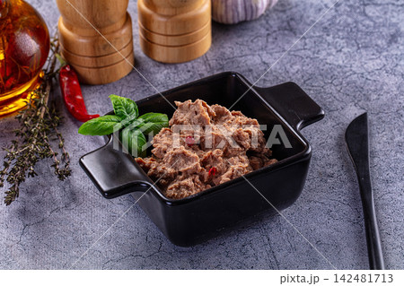 Liver pate in black ceramic bowl with fresh basil and spices on grey textured background Liver pate in black ceramic bowl with fresh basil and spices on grey textured background 142481713