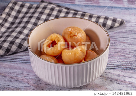 Canned longan in white ceramic bowl on rustic wooden table 142481962