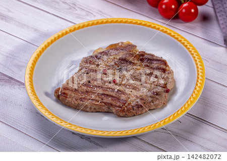 Grilled pork neck steak seasoned with pepper on white plate Grilled pork neck steak seasoned with pepper on white plate 142482072