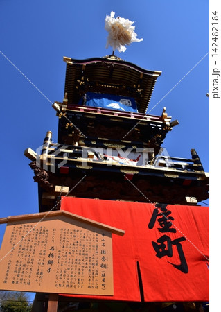 日本の愛知県の犬山祭り　車山と呼ばれる豪華な山車と木造の看板　満開の桜と美しい青空 142482184