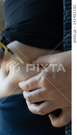 Woman making hormone injection into belly at home for ivf fertility treatment and ovulation stimulation. Concept of reproductive medicine, hormone therapy, and subcutaneous injection. Woman making hormone injection into belly at home for ivf fertility treatment and ovulation stimulation. Concept of reproductive medicine, hormone therapy, and subcutaneous injection. 142482192