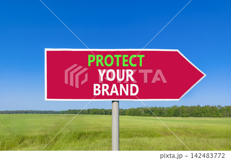 Protect your brand words symbol. Concept words Protect your brand on beautiful red road sign. Beautiful blue sky green grass background. Business and protect your brand concept. Copy space. 142483772
