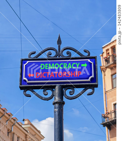 Democracy or dictatorship words symbol. Concept words Democracy Dictatorship on beautiful blue road sign. Beautiful blue sky background. Business democracy dictatorship concept. Copy space Democracy or dictatorship words symbol. Concept words Democracy Dictatorship on beautiful blue road sign. Beautiful blue sky background. Business democracy dictatorship concept. Copy space 142483809