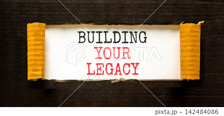 Building your legacy words symbol. Concept words Building your legacy on beautiful white paper. Beautiful black background. Business building your legacy concept. Copy space. Building your legacy words symbol. Concept words Building your legacy on beautiful white paper. Beautiful black background. Business building your legacy concept. Copy space. 142484086