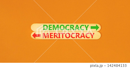 Democracy or meritocracy words symbol. Concept words Democracy Meritocracy on beautiful wooden sticks. Beautiful orange background. Business democracy meritocracy concept. Copy space Democracy or meritocracy words symbol. Concept words Democracy Meritocracy on beautiful wooden sticks. Beautiful orange background. Business democracy meritocracy concept. Copy space 142484133