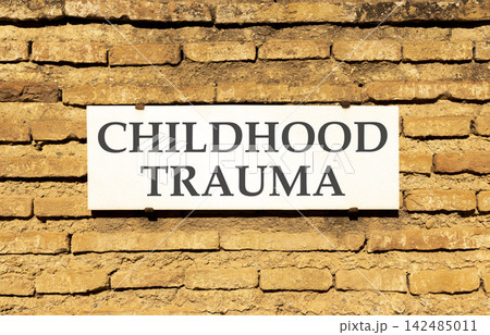 Childhood trauma words symbol. Concept words Childhood trauma on beautiful white sign plate. Beautiful brown brick wall background. Psychological childhood trauma support concept. Copy space. 142485011