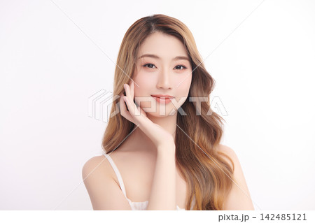 A beautiful young Asian woman with clean, fresh skin against a white background. Skincare, facial treatment, cosmetology, beauty, and spa. An elegant portrait of an Asian woman. 142485121
