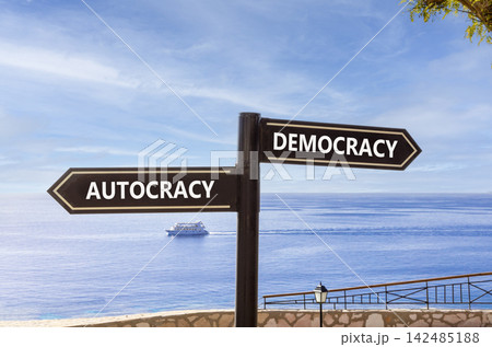 Democracy or autocracy words symbol. Concept words Democracy Autocracy on beautiful black road sign. Beautiful blue sky background. Business democracy autocracy concept. Copy space 142485188