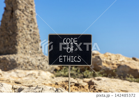 Code of ethics words symbol. Concept words Code of ethics on beautiful black blackboard. Beautiful stone and blue sky background. Business Code of ethics concept. Copy space. Code of ethics words symbol. Concept words Code of ethics on beautiful black blackboard. Beautiful stone and blue sky background. Business Code of ethics concept. Copy space. 142485372