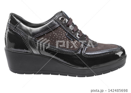 Dark brown patent leather womens wedge sneaker isolated on white background. Casual platform shoe side view Dark brown patent leather womens wedge sneaker isolated on white background. Casual platform shoe side view 142485698